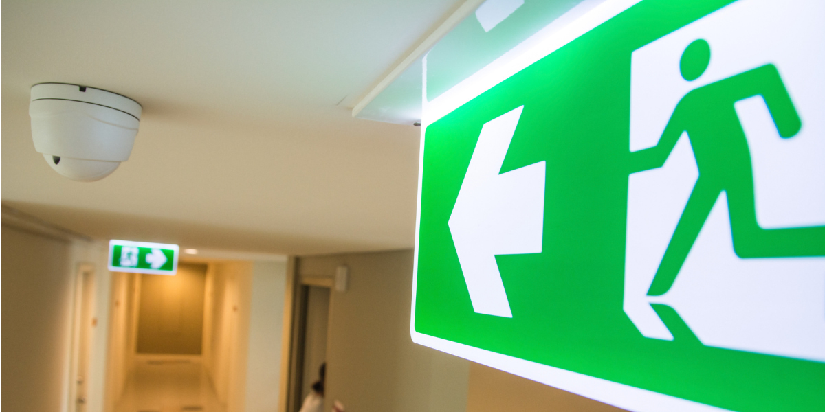An image of a UK fire exit sign in a building by Melwood Facilities.